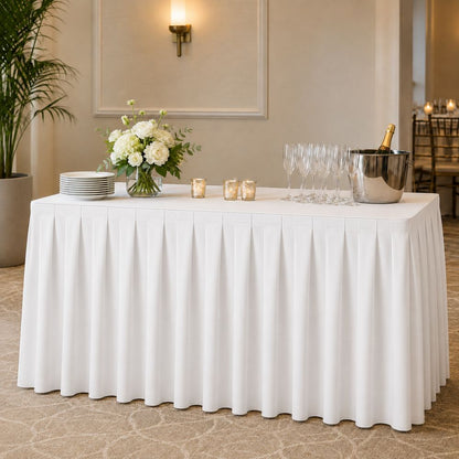 White pleated banquet table skirt for hotels, restaurants, weddings, catering and event venues, shown on a professionally styled rectangular table.