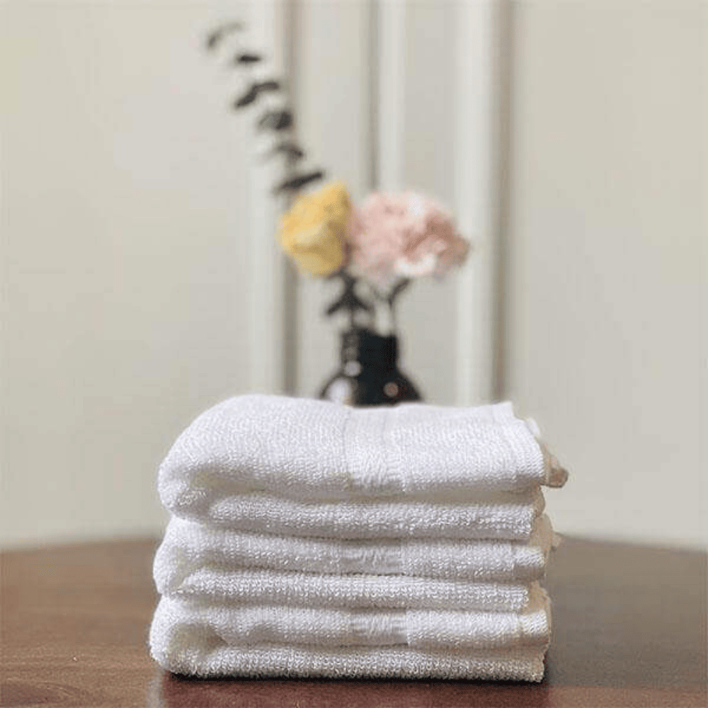 Wholesale white cotton towels for luxury hotels Premium Hand Towel folded on table.