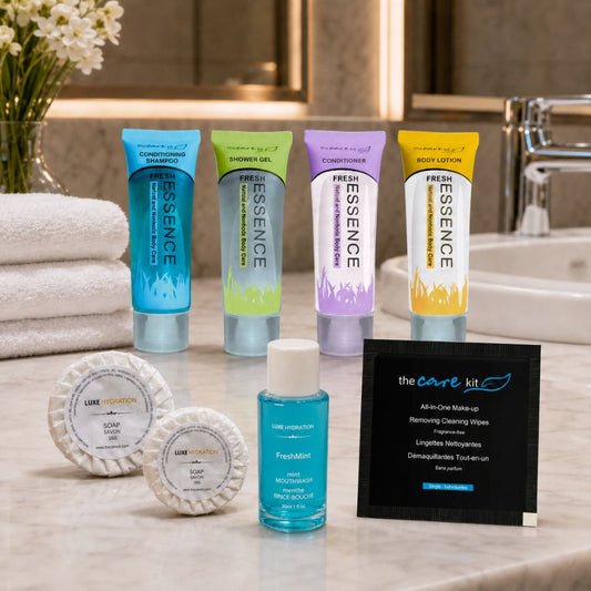 Fresh Essence hospitality amenities displayed in a hotel bathroom with toiletries, soaps, mouthwash and makeup remover wipe.