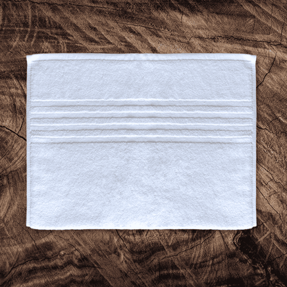 White cotton towels wholesale for hotel chains Four Striped Hand Towel - 16x27" on table.